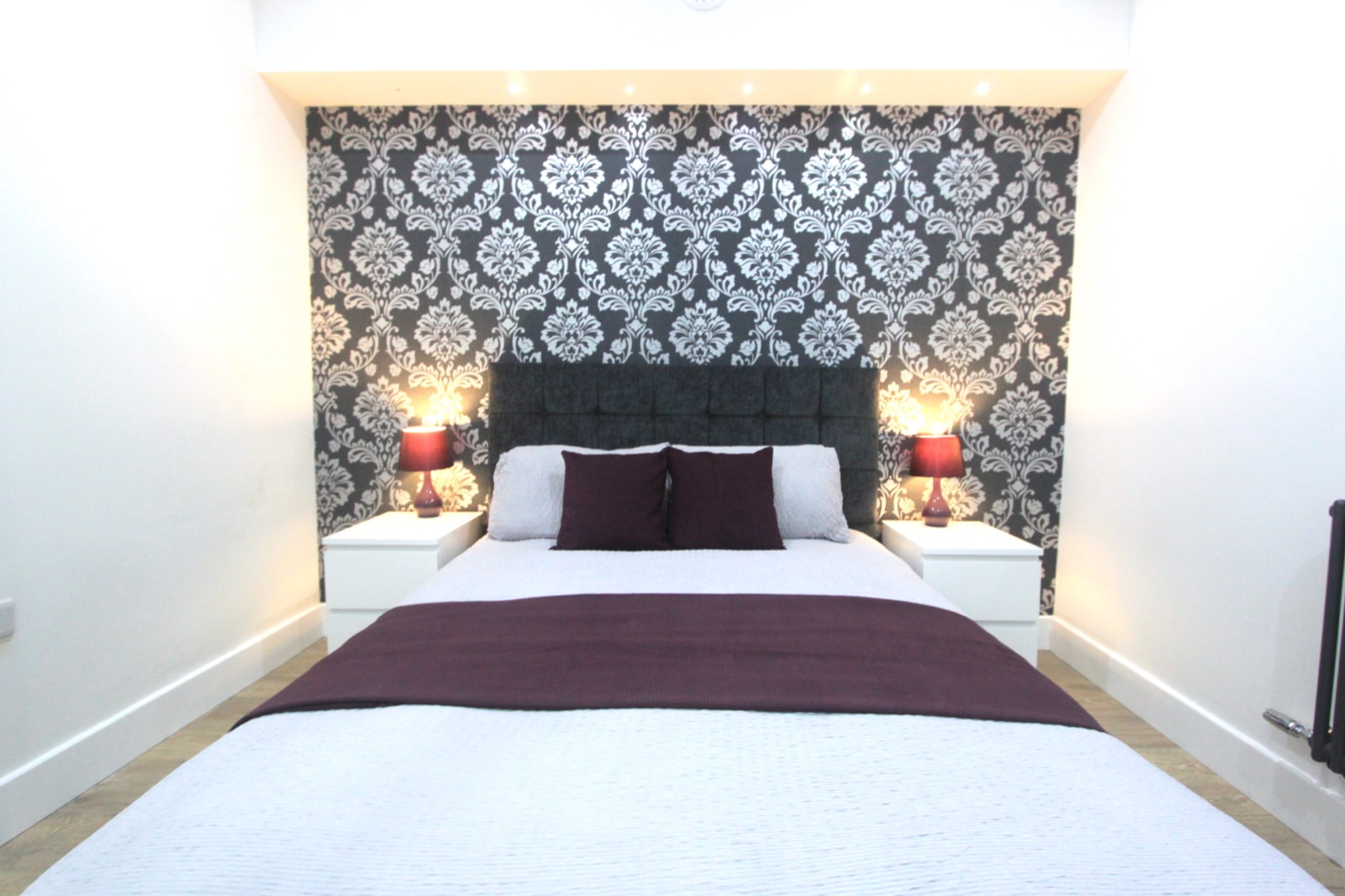 Furnished double bedroom with upholstered bed