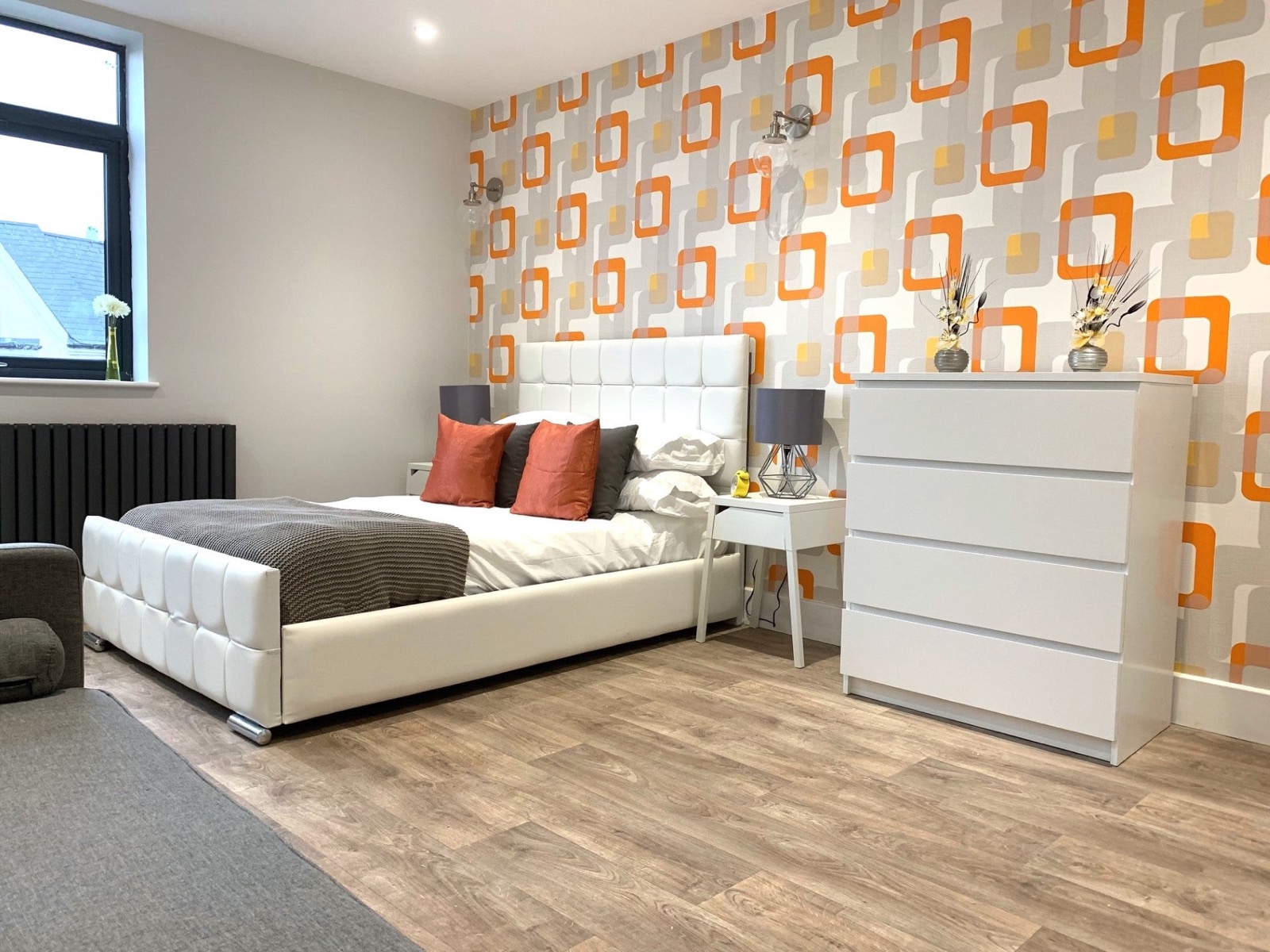 Double bedroom with a patterned feature wall and bedside lamps