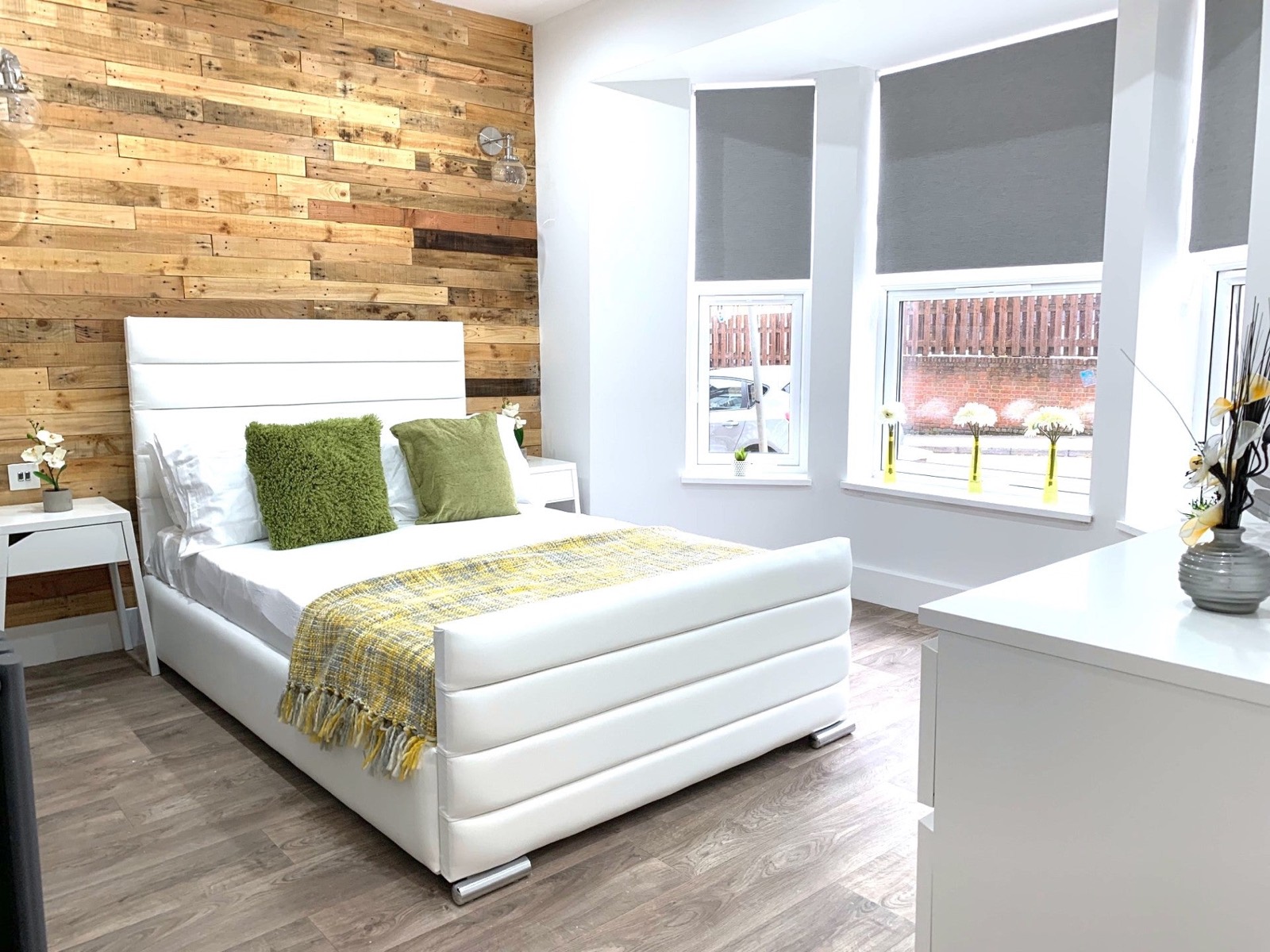 Bright bedroom with a reclaimed timber wall and white double bed