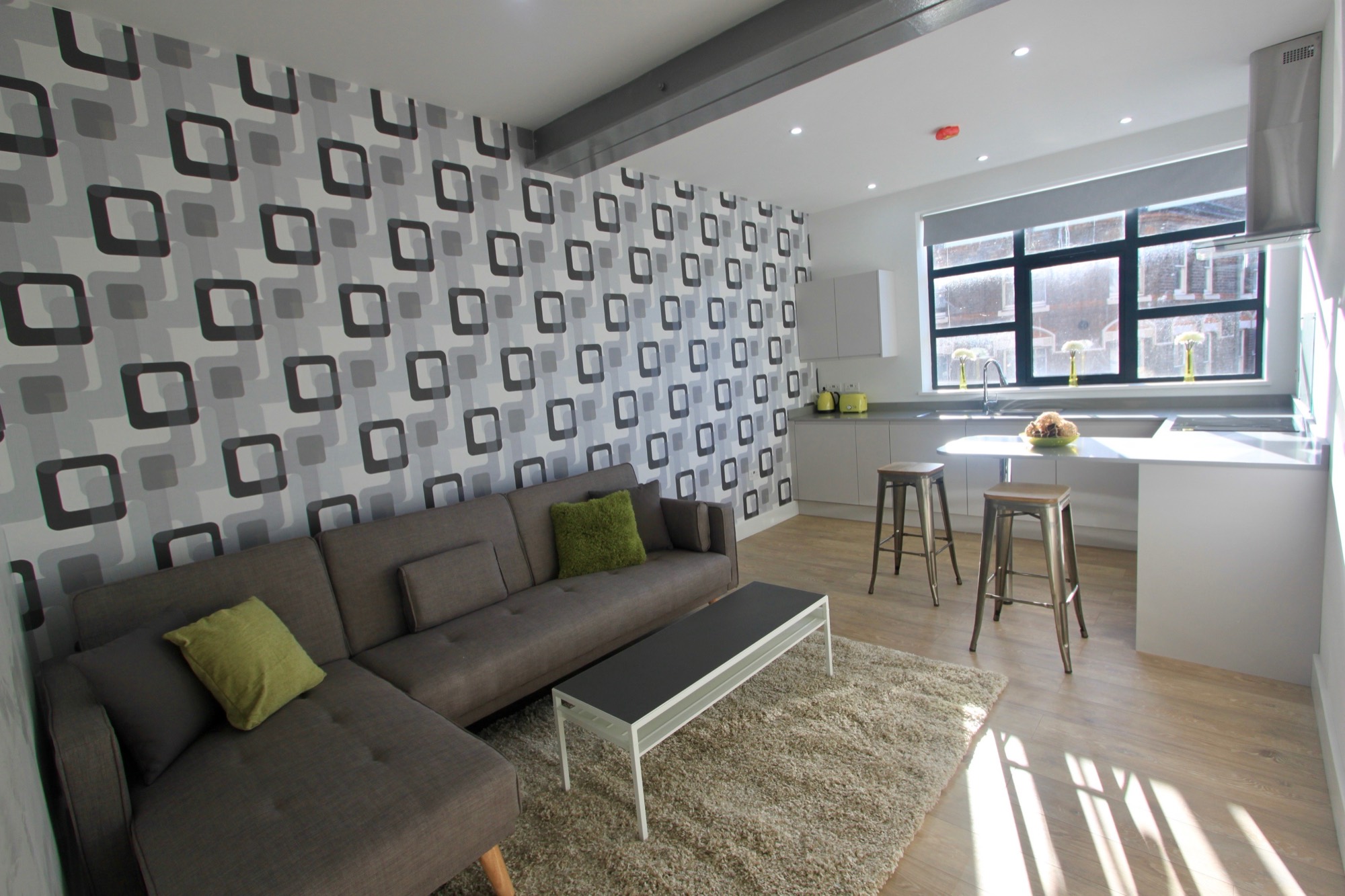 Open-plan living area with exposed beams and large windows