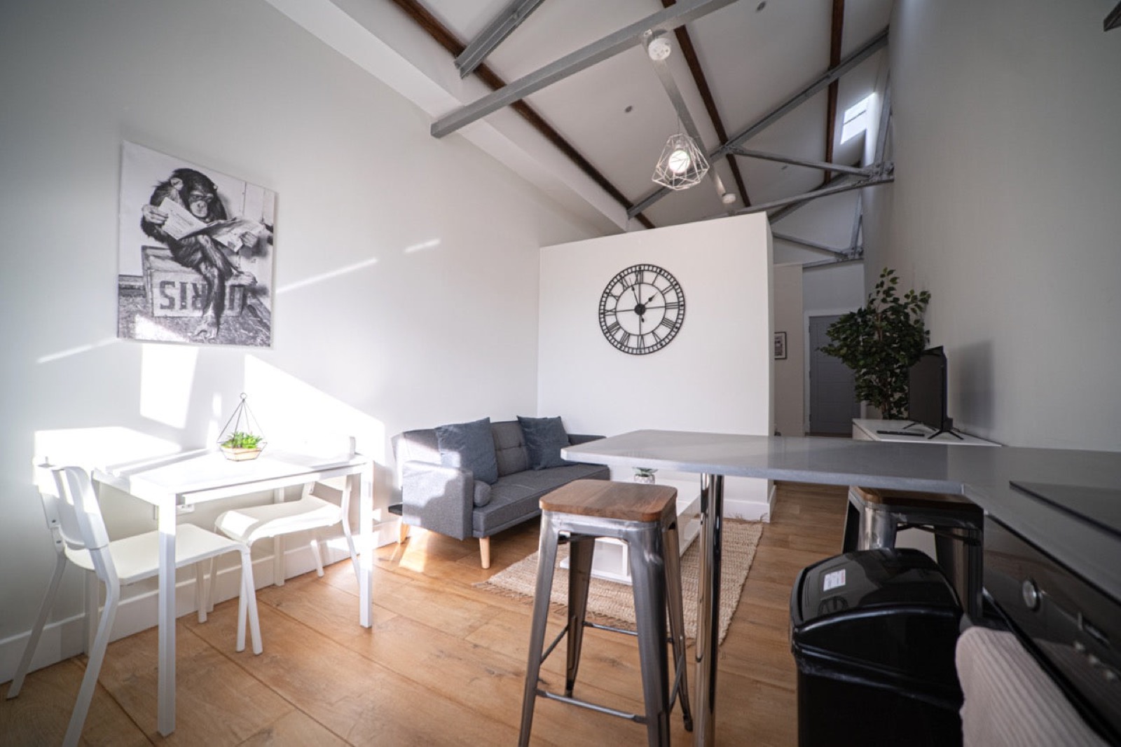 Loft-style studio flat with beams, sofa and breakfast bar